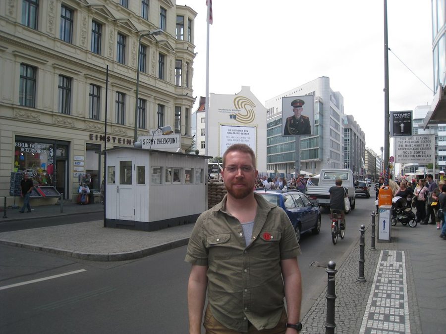 Andrew standing in front of Checkpoint Charlie in Berlin